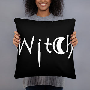 The word Witch in white creepy letters on a black pillow
