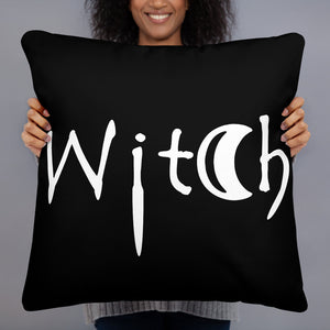 The word Witch in white creepy letters on a black pillow