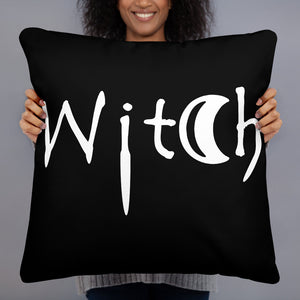 The word Witch in white creepy letters on a black pillow